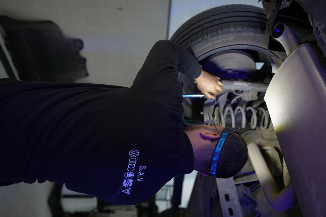 Technicien SAV intervenant sous un véhicule